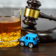 toy car next to whiskey and gavel